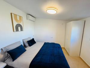 a bedroom with a large bed with blue pillows at Casa Indigo Mazarron in Mazarrón +41 photos
