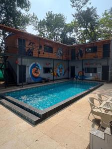 a large swimming pool in front of a building at Simple Belle Stay ,Pool &Bar in Vagator