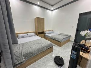 a small bedroom with two beds and a tv at Muối Hồng Homestay in Ấp Tân Hà