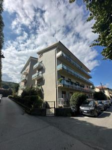 a large building with cars parked in a parking lot at Fior&Iris Delux in Stresa