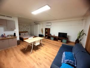 a living room with a blue couch and a table at Studio Piscine à Saint-Gilles prés des plages in L'Ermitage-Les-Bains