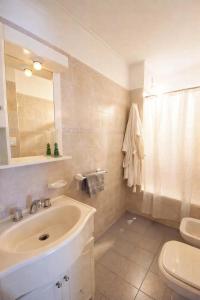 a bathroom with a sink and a toilet and a mirror at Departamento CBA in Córdoba