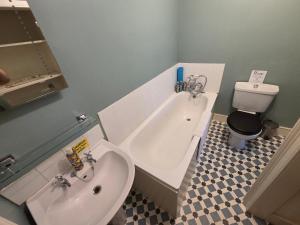 a bathroom with a sink and a tub and a toilet at Old Manor House in Shepperton +30 photos