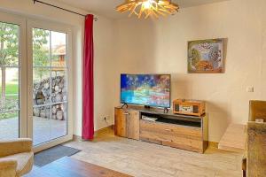 a living room with a flat screen tv and a window at Blockhaus Baum 3 in Burg