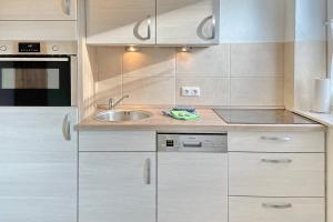 a kitchen with white cabinets and a sink at Blockhaus Baum 3 in Burg