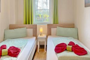 two beds in a small room with a window at Blockhaus Baum 3 in Burg