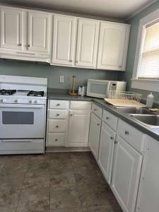a kitchen with white cabinets and white appliances at OCHG 306 Talbot Top in Ocean City +10 photos