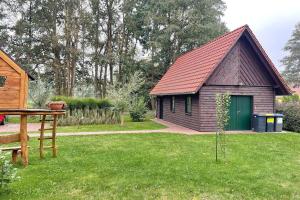 a small house with a green door in a yard at Baumhaus Baum 4 in Burg