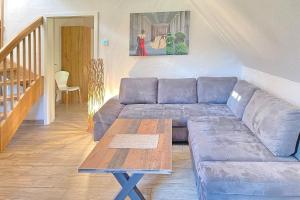 a living room with a blue couch and a table at Baumhaus Baum 4 in Burg