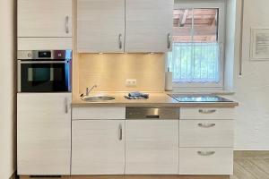 a kitchen with white cabinets and a sink and a window at Baumhaus Baum 4 in Burg +13 photos