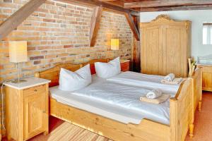 a bedroom with a wooden bed and a brick wall at Altstadtflair - Rüster in Lübbenau