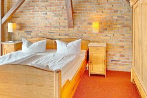 a bedroom with two beds and a brick wall at Altstadtflair - Rüster in Lübbenau