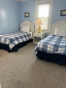 a bedroom with two beds and a table with a lamp at OCHG 306 Talbot in Ocean City +11 photos