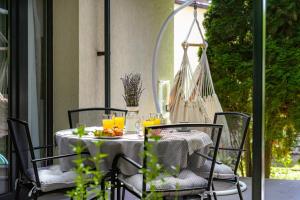 a table and chairs on a porch with a table and drinks at Jázmin Chill Cottage in Bánk