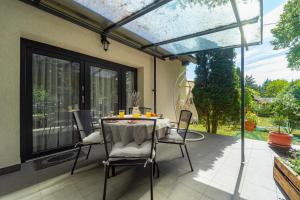 a patio with a table and chairs on it at Jázmin Chill Cottage in Bánk
