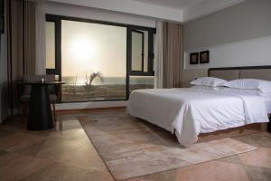 a bedroom with a large bed and a large window at Jardin d'orient in Dakar