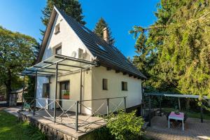 a small white house with a porch and a table at Jázmin Chill Cottage in Bánk +46 photos