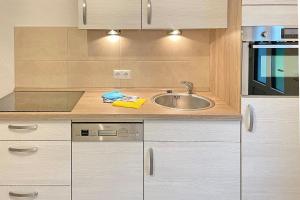 a kitchen with white cabinets and a sink at Holzfäller Baum 2 in Burg