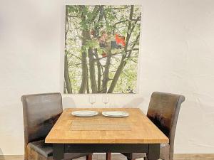 a wooden table with two chairs and a picture on the wall at Holzfäller Baum 2 in Burg