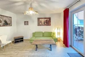 a living room with a green couch and a table at Holzfäller Baum 2 in Burg