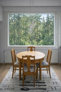 a wooden table and chairs in a room with a window at 1-Bedroom Apartment with Sauna in Heinola