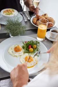 a table with a plate of eggs and vegetables on it at Mr and Mrs White Oia - Santorini in Oia +70 photos