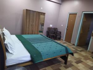 a bedroom with a bed with a green blanket on it at The pine view Orchard homestay in Rāmgarh