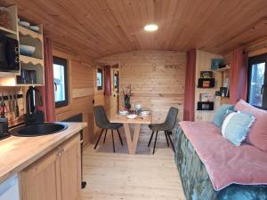 a room with a bed and a table in a tiny house at Roulotte Gîtes O bien-être massage Spa Séjour bien-être en hébergement insolite roulotte Karantez ou en gîtes Melon ou Yock à 800 m des plages in Porspoder