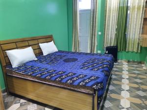 a bedroom with a bed with a blue comforter at The pine view Orchard homestay in Rāmgarh +3 photos