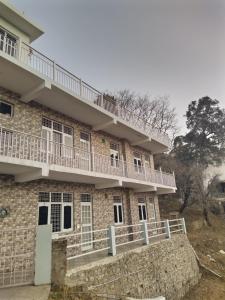 a building with balconies on the side of it at The pine view Orchard homestay in Rāmgarh
