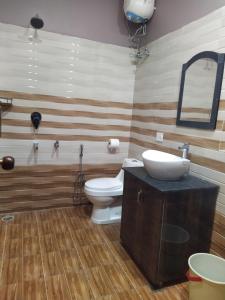 a bathroom with a toilet and a sink at The pine view Orchard homestay in Rāmgarh