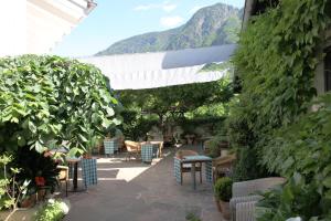 eine Terrasse mit Stühlen und Tischen mit einem Berg im Hintergrund in der Unterkunft Hotel Sparerhof in Vilpian