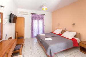 a hotel room with a bed and a television at Dream House in Agia Paraskevi