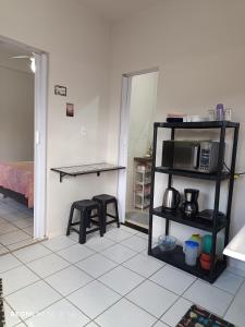 a kitchen with a table and a shelf with a microwave at LAR DE PRAIA - Suíte in Serra +9 photos