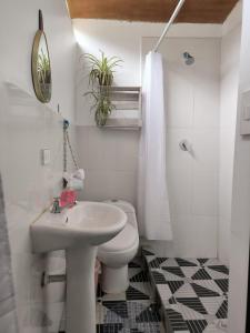 a white bathroom with a toilet and a sink at The Willow B&B in Urubamba
