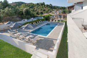 a swimming pool with chairs and umbrellas on a building at Dream House in Agia Paraskevi
