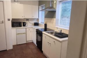 a kitchen with white cabinets and a black stove top oven at Private Studio Apartment · Quiet · Sleeps 2 in Nottingham