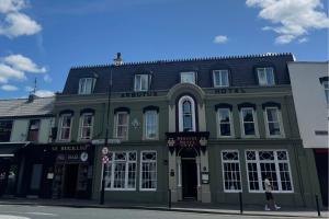 a green building on the corner of a street at Arbutus Hotel in Killarney