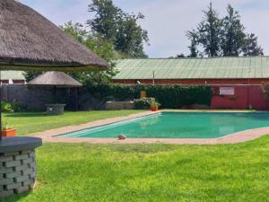 a swimming pool in a yard next to a building at Bostons Lodge & Restaurant in Jan Kempdorp