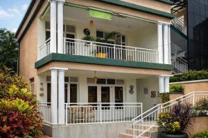 a white house with a balcony on top of it at ADRIEL HOMES KIGALi in Kigali