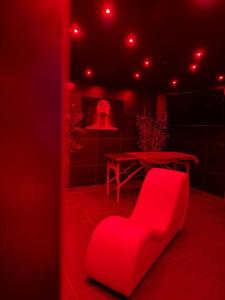 a red room with a red chair and a table at Love Room- Jacuzzi XXL- Climatisé- Table massage Accessoires in LʼEscarène +2 photos