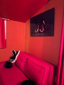 a red room with a couch with a stuffed animal on it at Love Room- Jacuzzi XXL- Climatisé- Table massage Accessoires in LʼEscarène