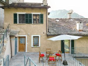a patio with a table and chairs and an umbrella at Casa Gemma in Rimella