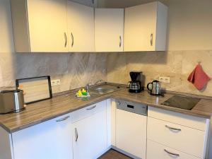 a kitchen with white cabinets and a sink at Malz in Lübbenau