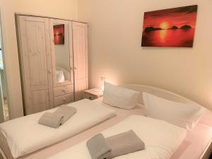 a bedroom with two white beds and a painting on the wall at Malz in Lübbenau