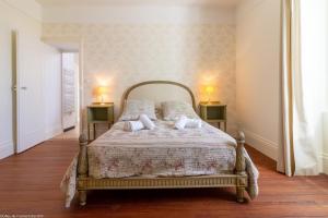 a bedroom with a bed with two lamps on two tables at L'orée du lac - Formule Chambres in Marcenay