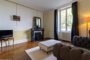 a living room with a couch and a fireplace at L'orée du lac - Formule Chambres in Marcenay
