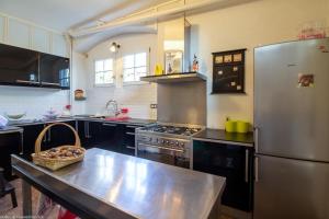 a large kitchen with a stainless steel refrigerator at L'orée du lac - Formule Chambres in Marcenay