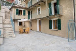 a patio with a table and an umbrella in front of a building at Casa Gemma in Rimella