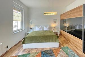 a bedroom with a large bed with a green blanket at Malve in Lübbenau